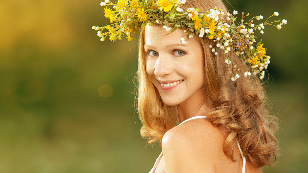 Красивая улыбающаяся девушка с венком из полевых цветов на голове