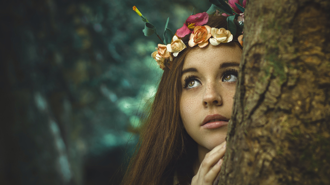 Девушка с венком на голове у дерева 