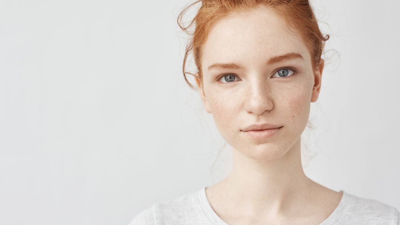 Рыжеволосая девушка на сером фоне