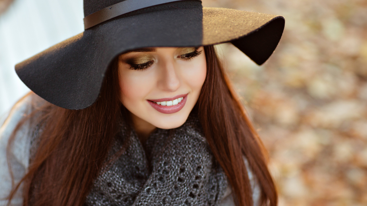 Улыбающаяся шатенка в большой черной шляпе