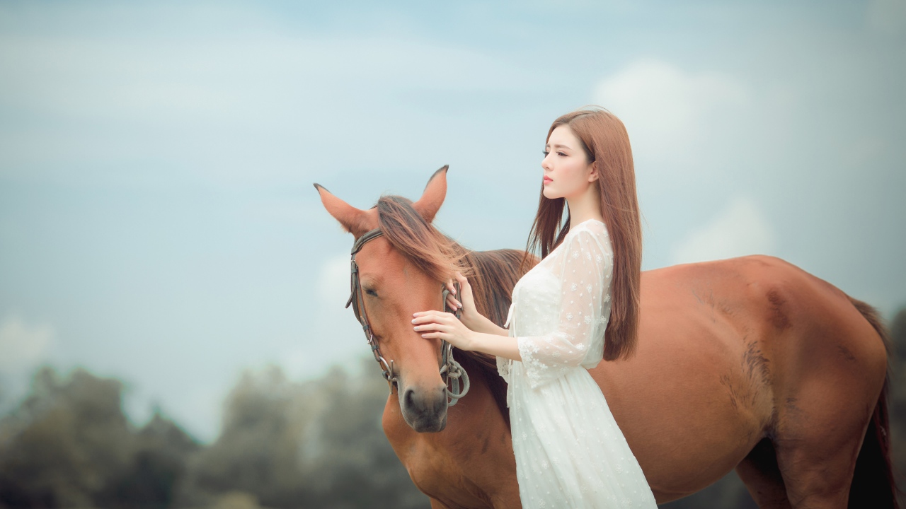 Молодая азиатка в белом платье с лошадью 