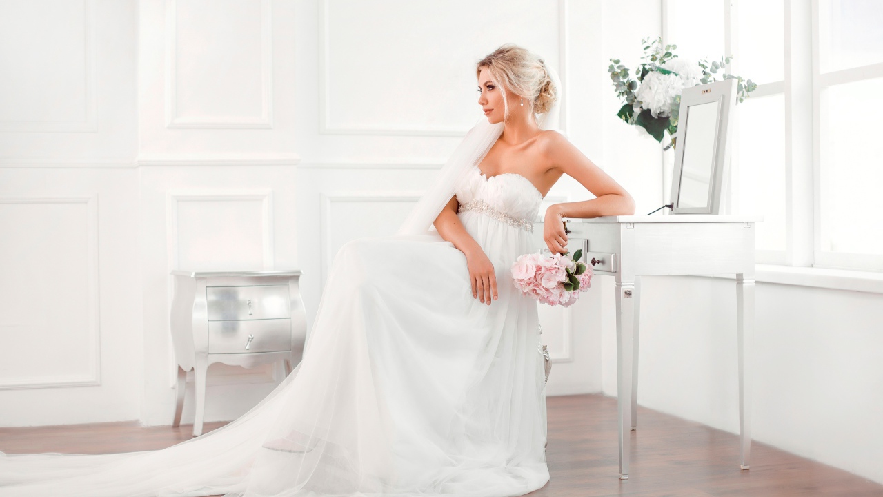 Молодая блондинка в красивом белом свадебном платье