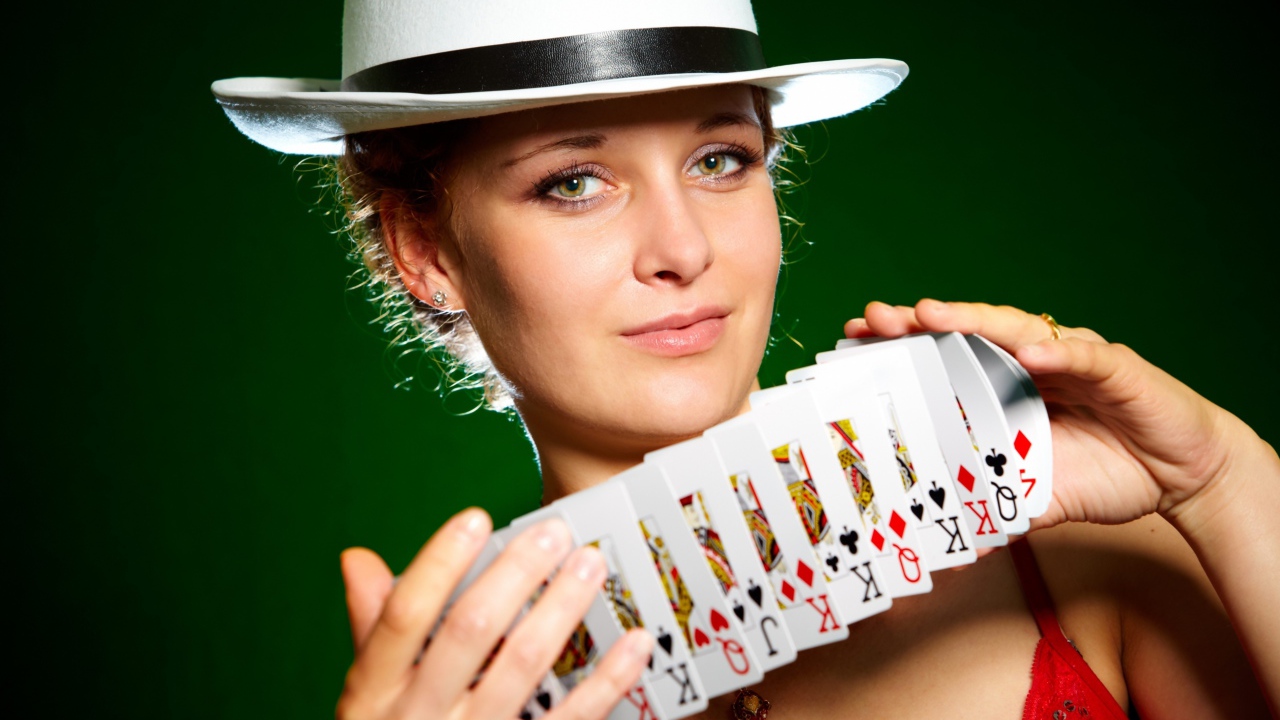 Молодая девушка в шляпе с картами в руках