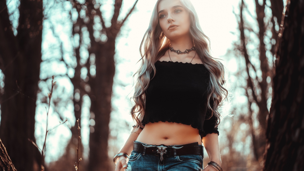 Молодая девушка в рваных джинсах с пирсингом в носу