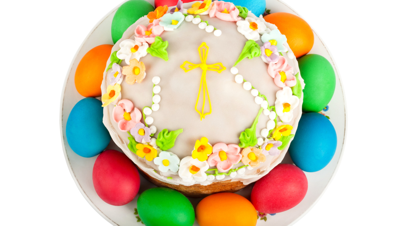 Красивый пасхальный кулич с цветами и разноцветными крашеными яйцами на белом фоне