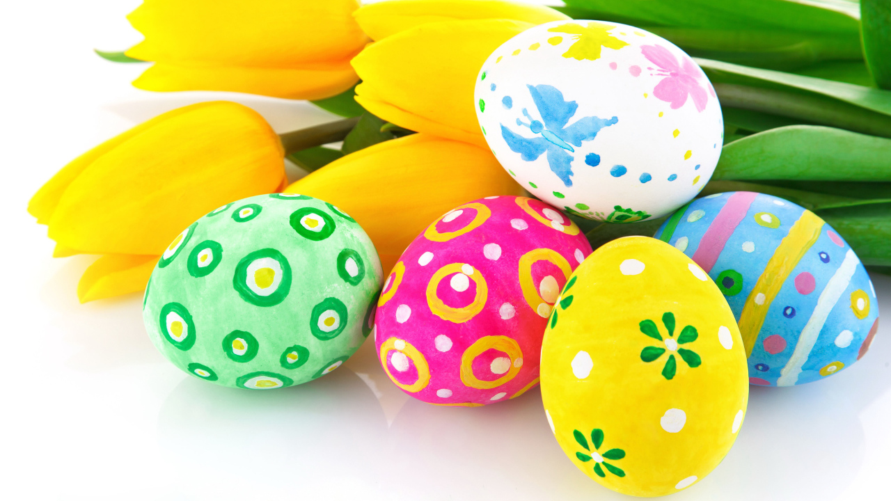 Разукрашенные яйца с букетом желтых тюльпанов на белом фоне на Пасху