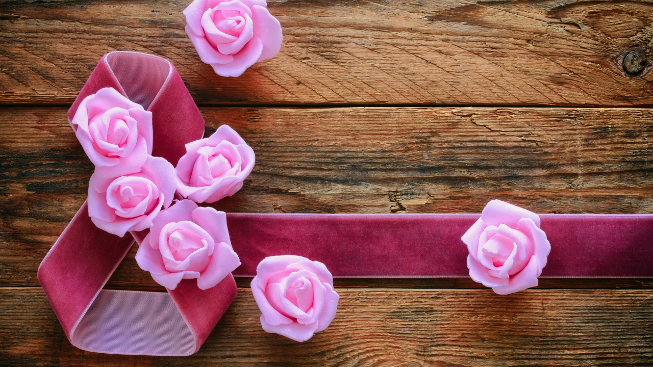 Восьмерка из ленты с розовыми розами на деревянном фоне на Международный женский день