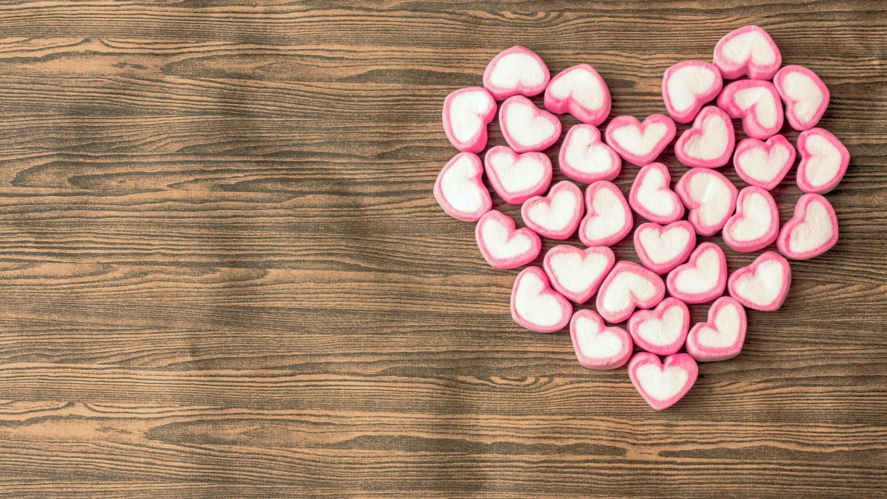 Сердце из конфет в форме сердца на деревянном столе