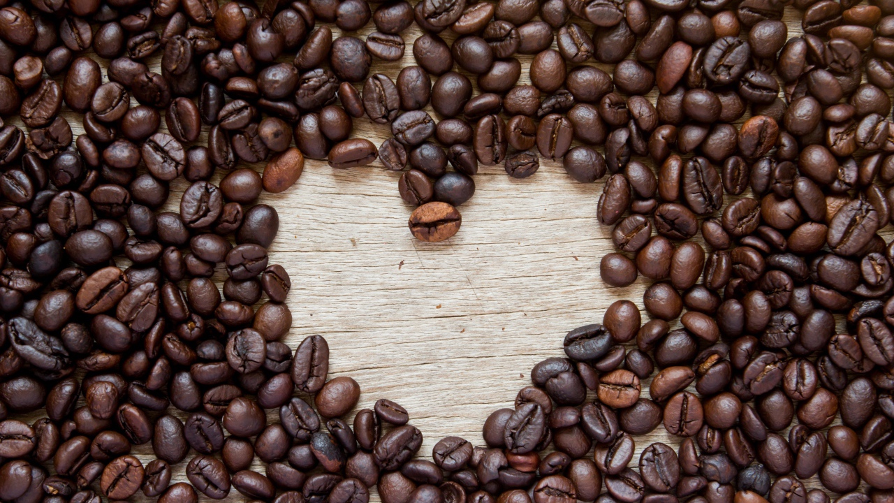 Сердце из кофейных зерен на деревянном столе 