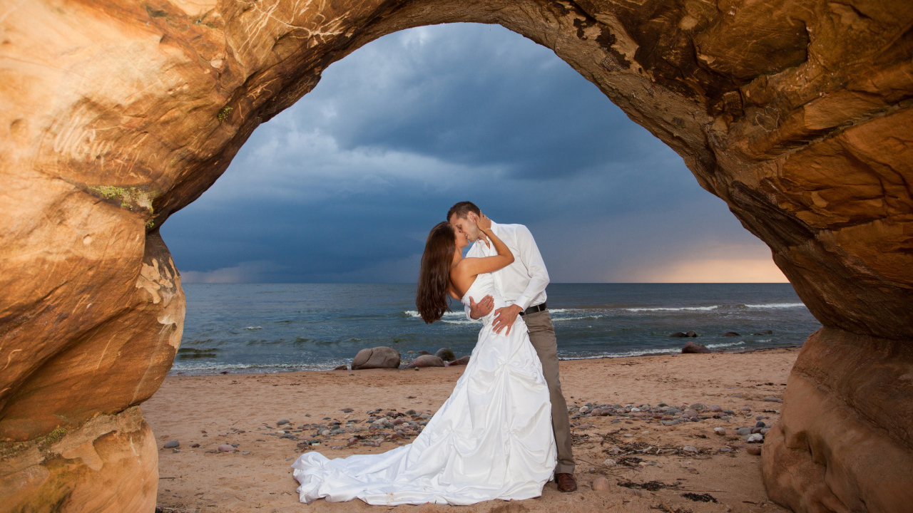 Поцелуй жениха и невесты на фоне моря