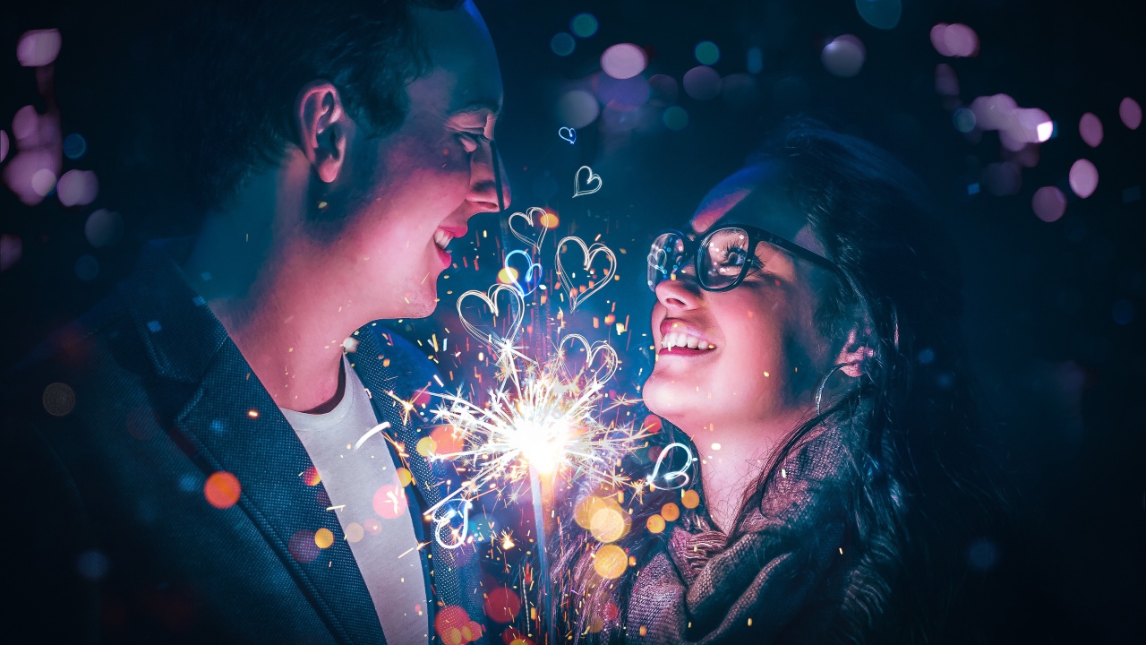 Влюбленные парень и девушка с бенгальским огнем в руке