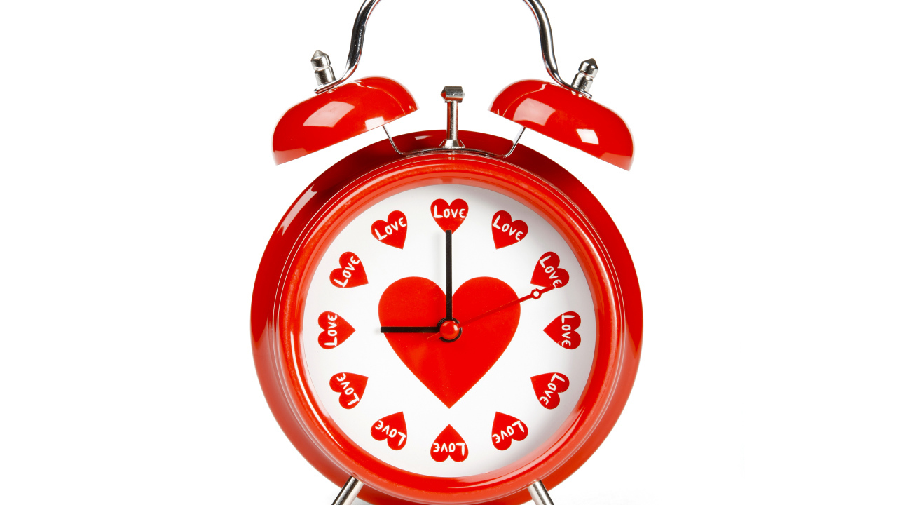 Красный будильник с сердечками на белом фоне