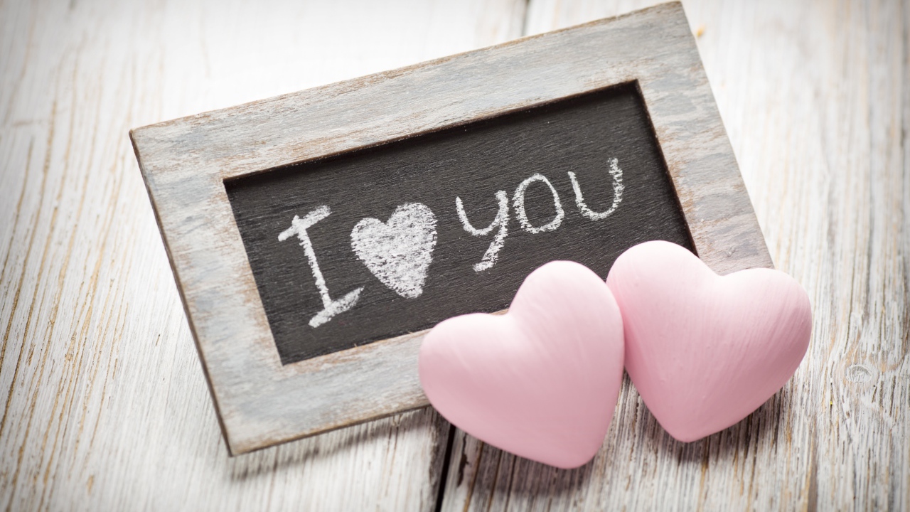 Два розовых сердца на столе с деревянной рамкой