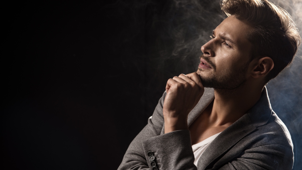 Красивый задумчивый мужчина в сером пиджаке