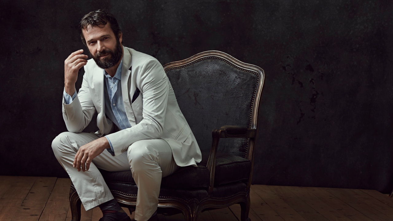 Актер Джеймс Пьюрфой сидит в кресле 