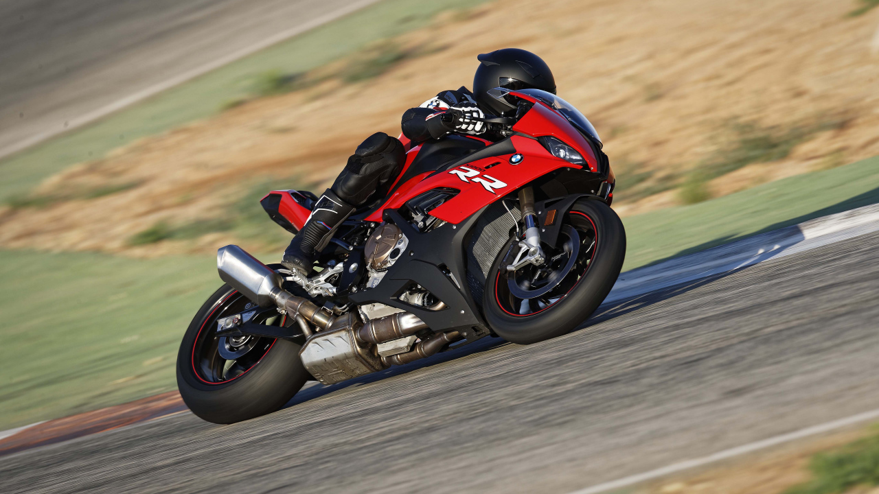 Гонщик на мотоцикле BMW S1000 совершает крутой поворот