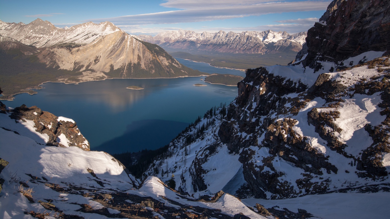 Озеро между заснеженных гор на фоне голубого неба