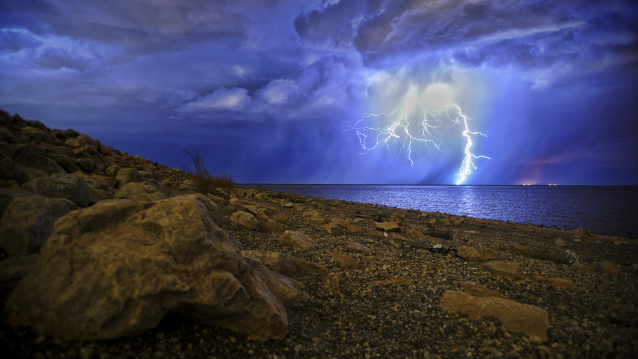 Молния в море пронзает грозовое небо 