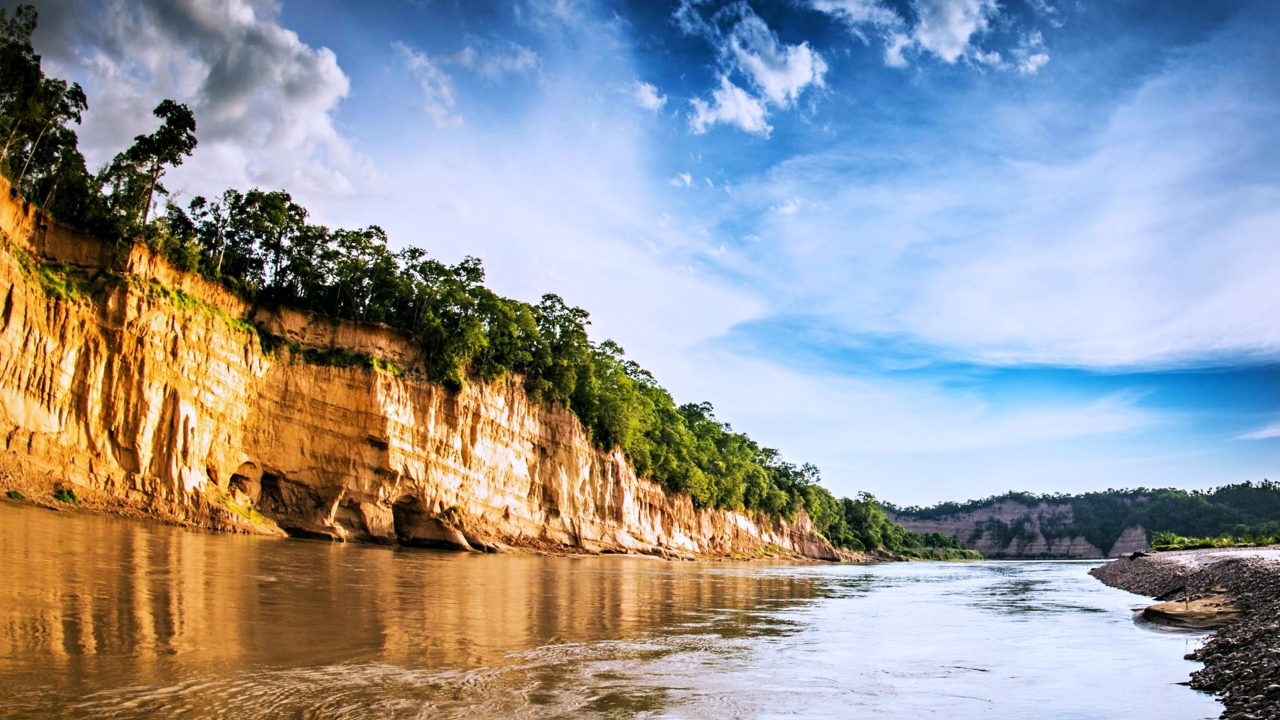 Скала на берегу реки под красивым небом