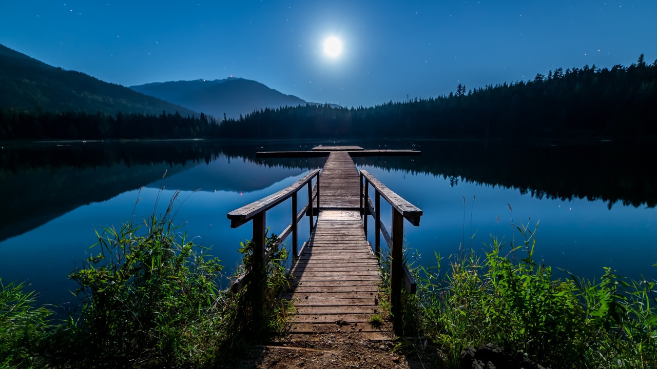 Деревянный мост на озере в полнолуние