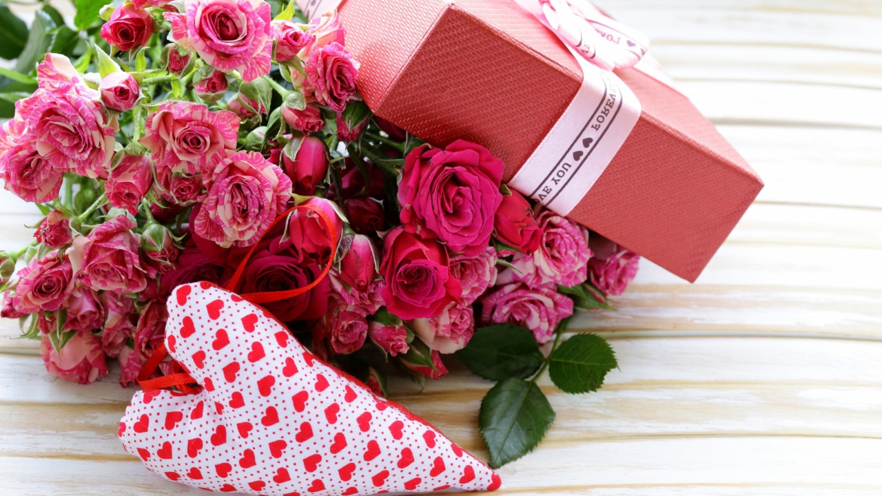 Букет розовых роз с подарком и сердечком на столе