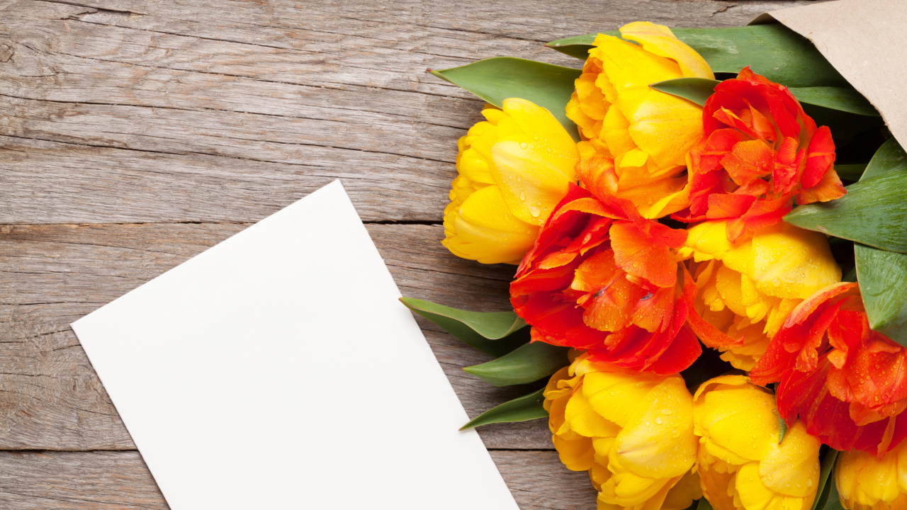 Букет желтых тюльпанов на столе с листом бумаги