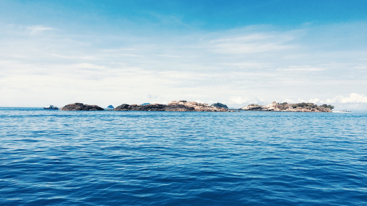 Спокойное синее море со скалами на горизонте