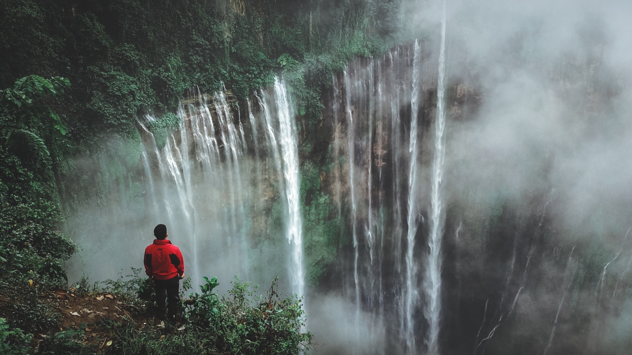 Человек смотрит на водопад сверху. 