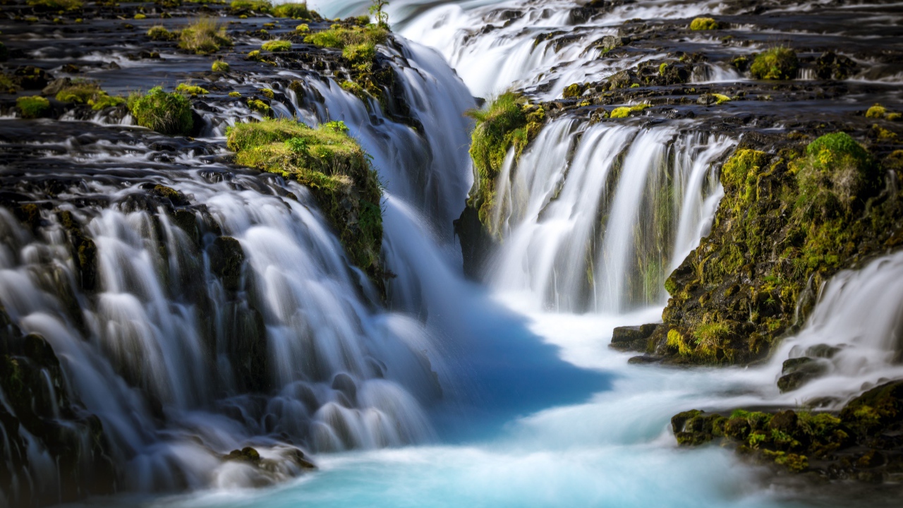 Быстрый водопад стекает по горам, Исландия
