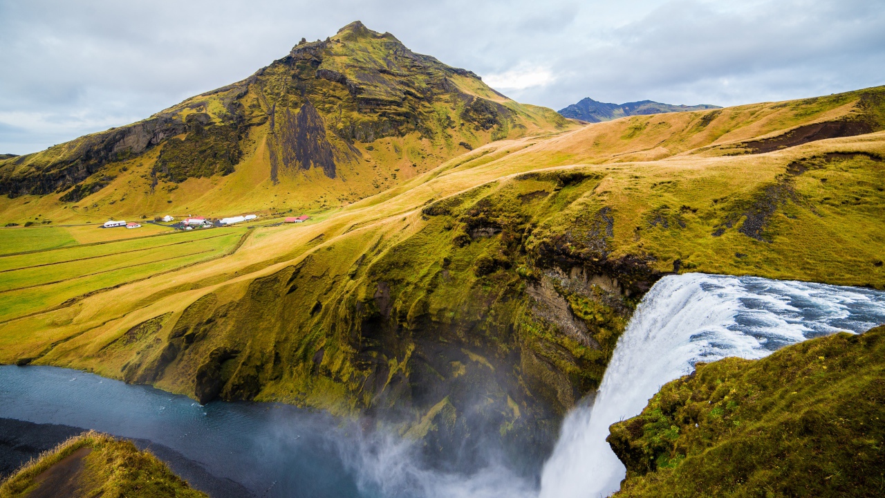 Водопад на фоне покрытых зеленью гор, Исландия