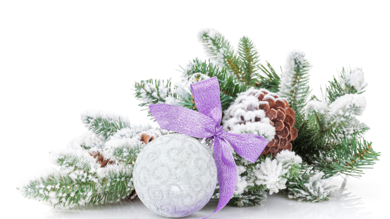 Серый елочный шар с бантом на зеленой ветке на Новый год 2019