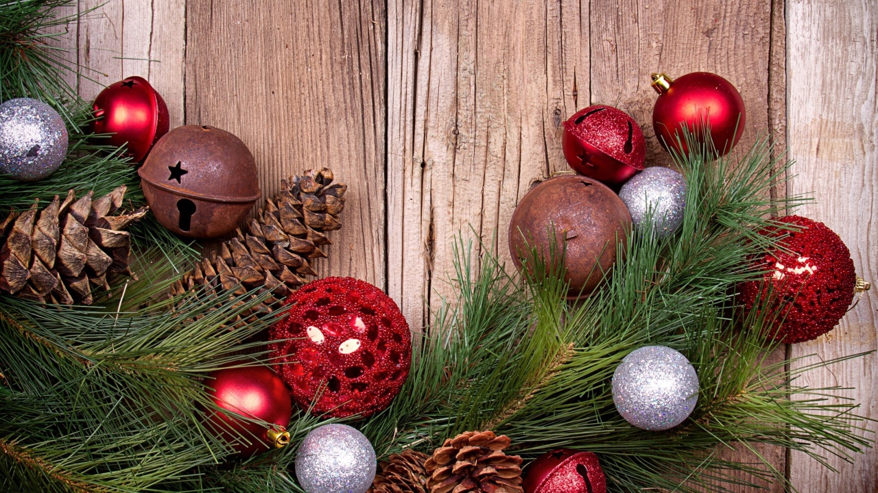 Зеленая еловая ветка с шишками и игрушками на деревянном фоне