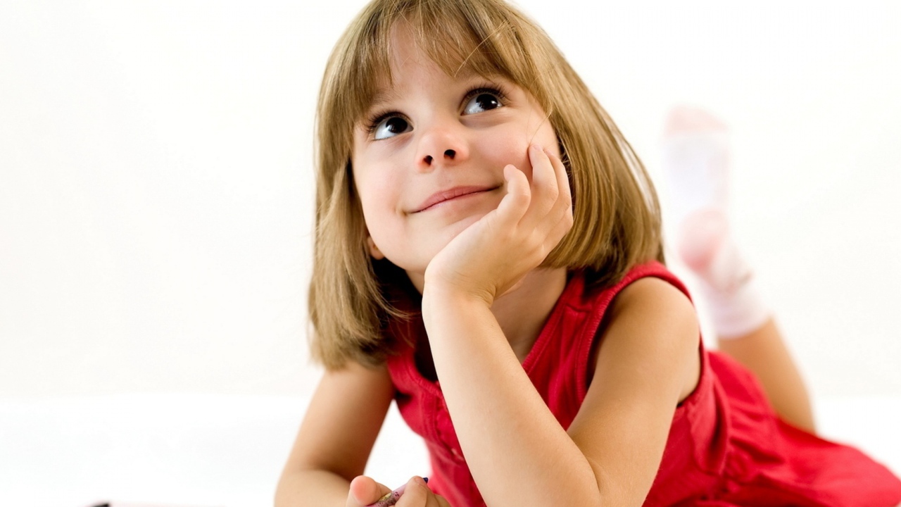 Милая девочка в красном платье рисует