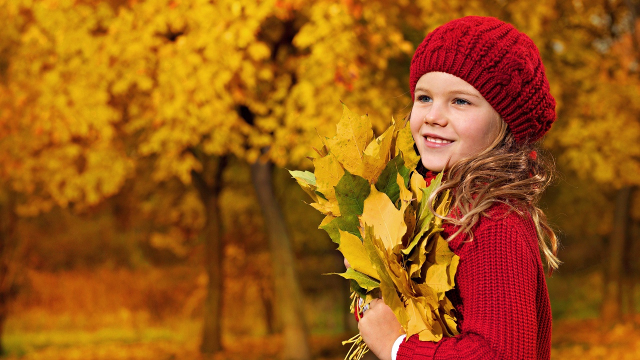Девочка в красном берете с желтыми листьями в руках