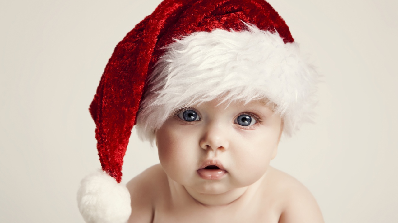 Голубоглазый малыш в красной шапке деда мороза