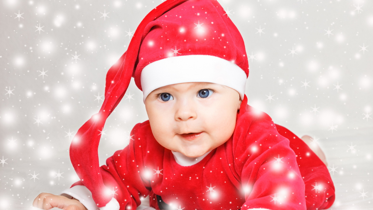 Милый голубоглазый ребенок в красном новогоднем костюме