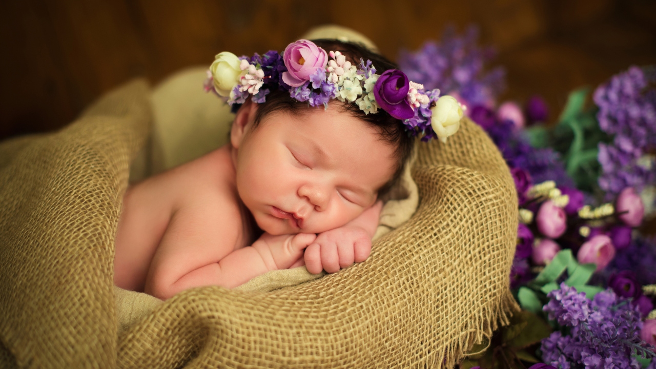 Милый спящий младенец с венком на голове