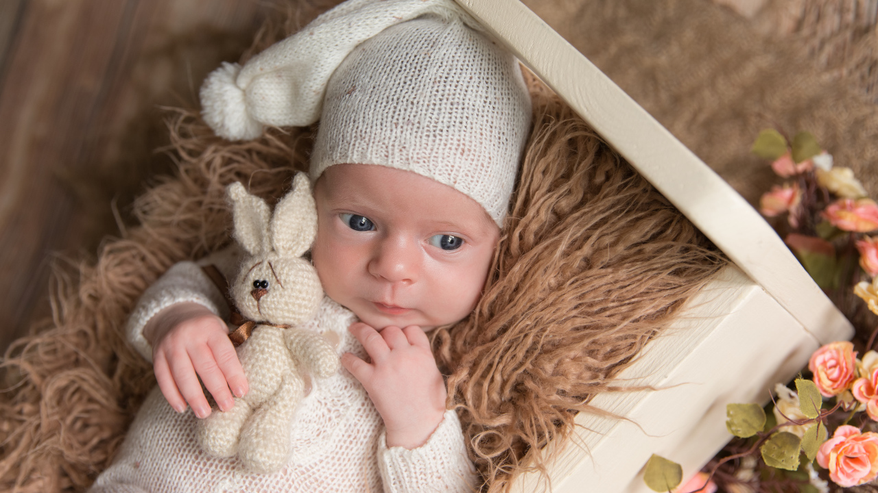 Маленький ребенок в вязанном костюме с зайчиком