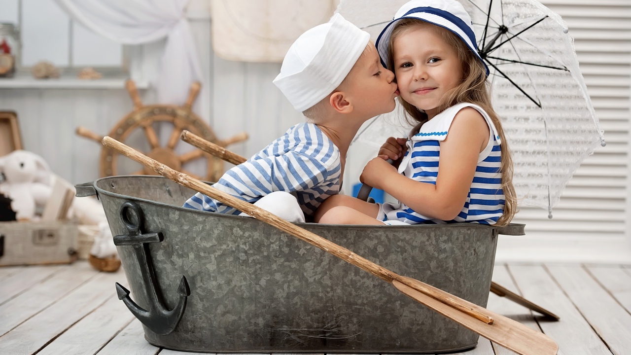 Маленькие мальчик и девочка сидят в железном корыте