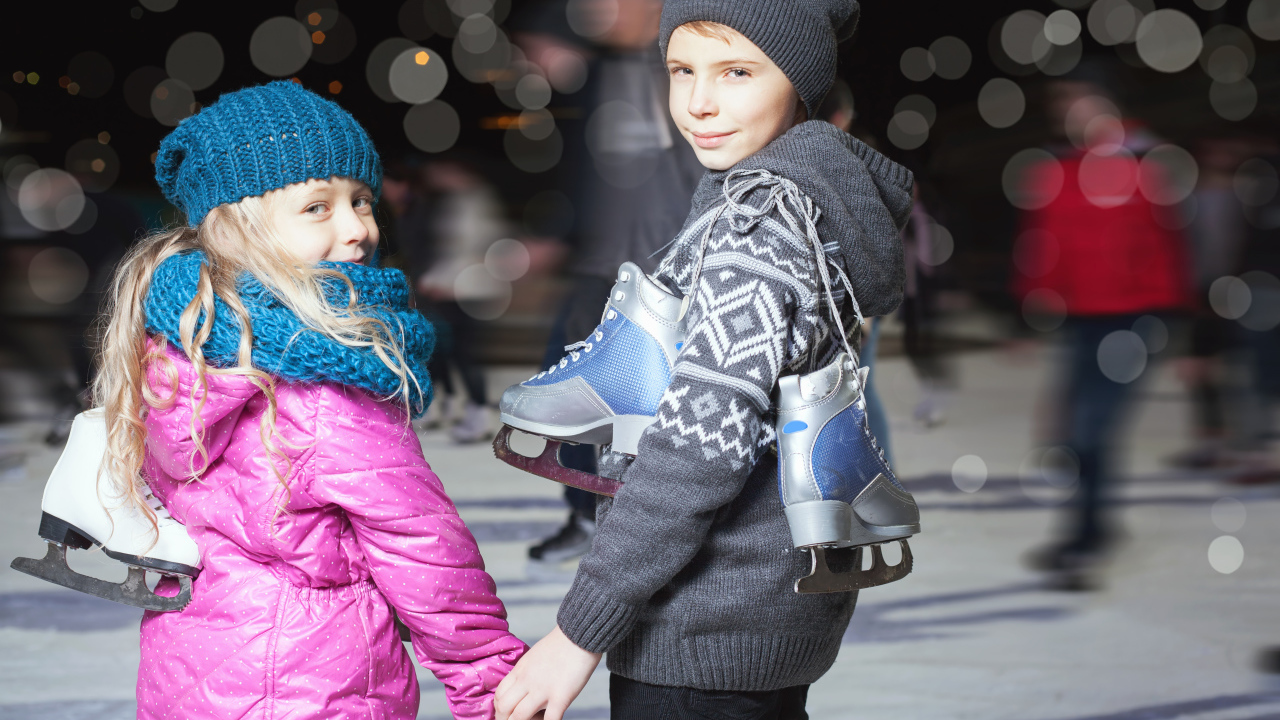 Маленькие мальчик и девочка на катке