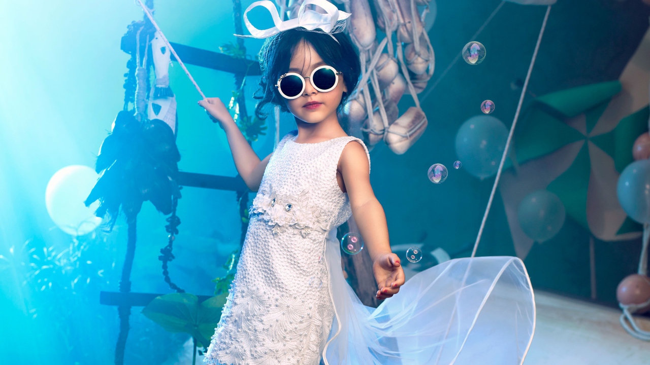 Маленькая девочка в белом платье и черных очках