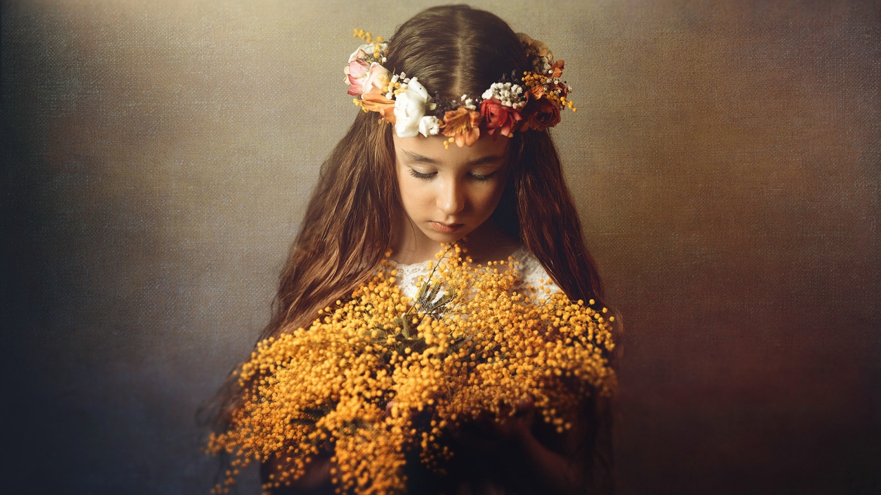 Маленькая девочка с букетом мимозы в руках