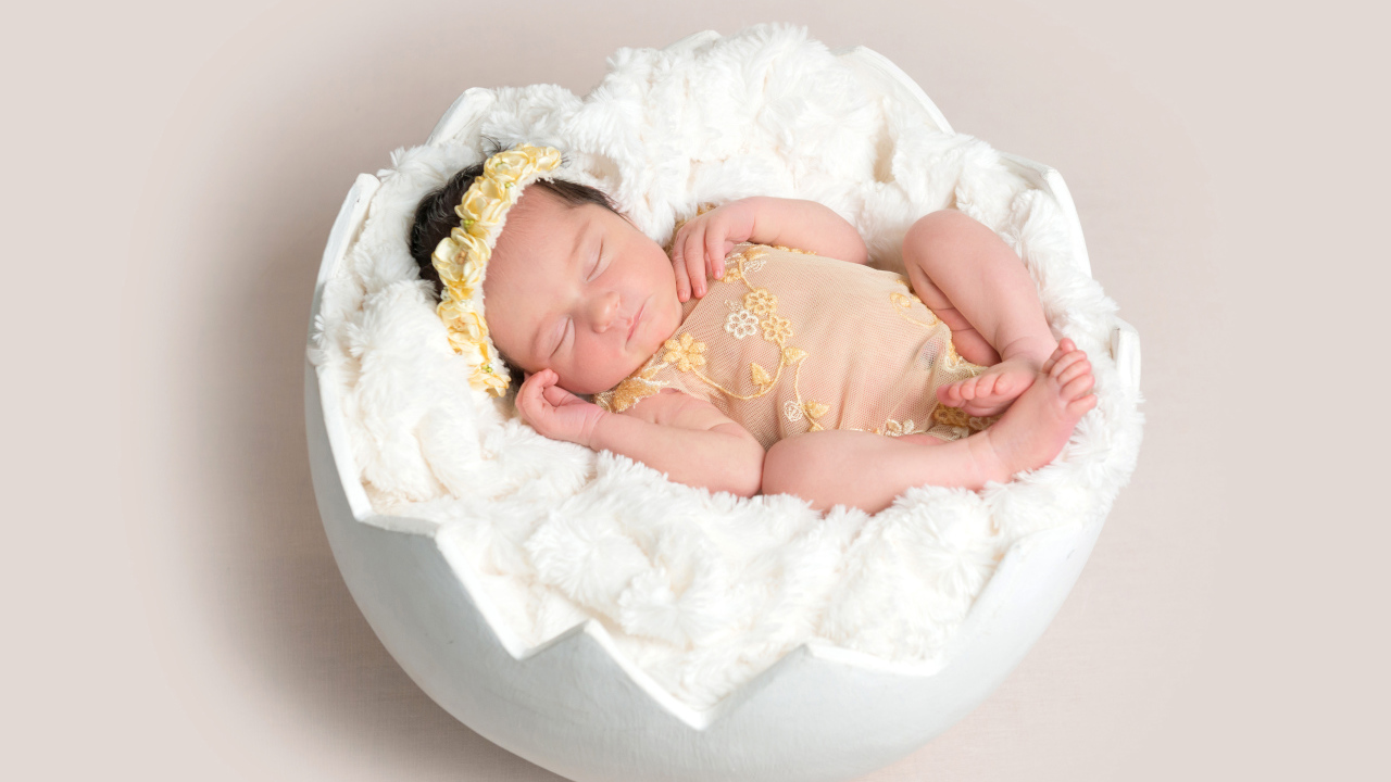 Маленькая новорожденная девочка в забавной колыбели