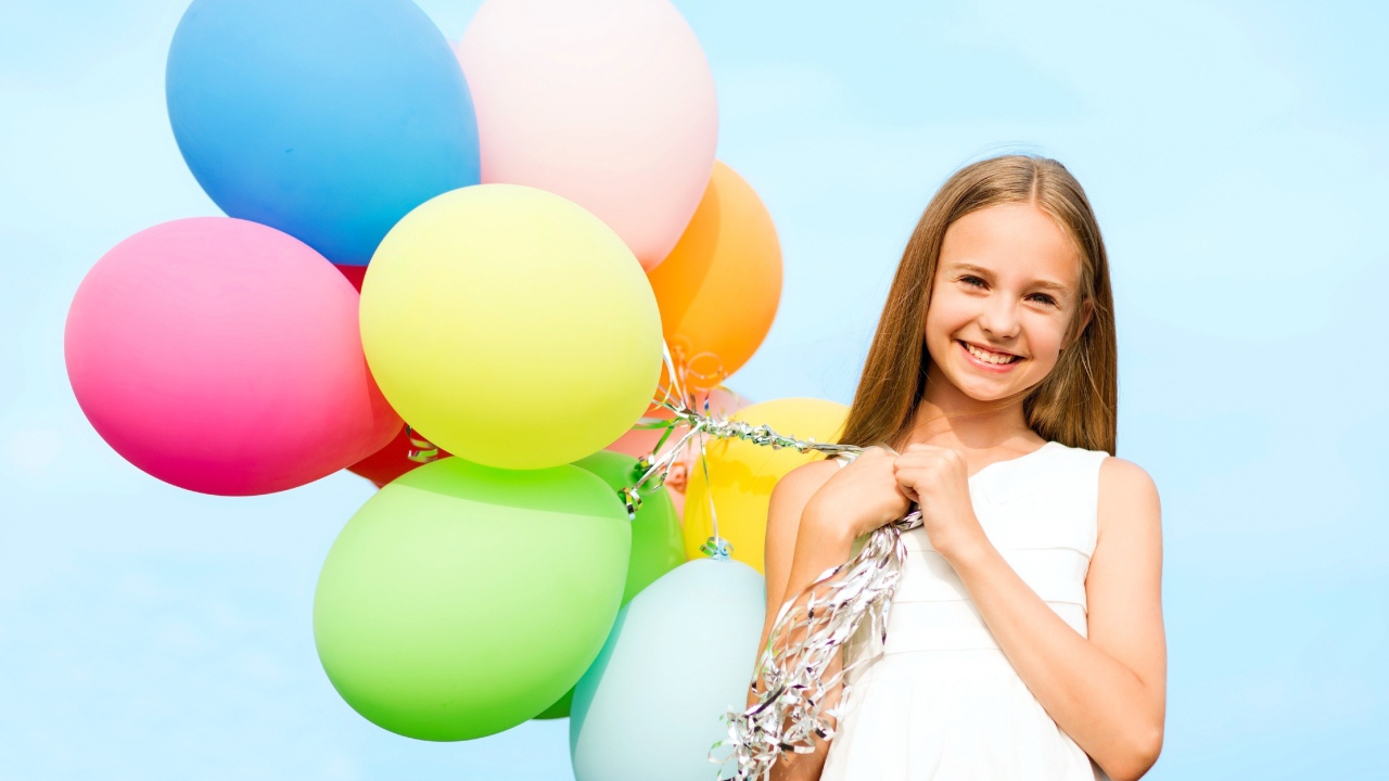 Улыбающаяся девочка с воздушными шарами