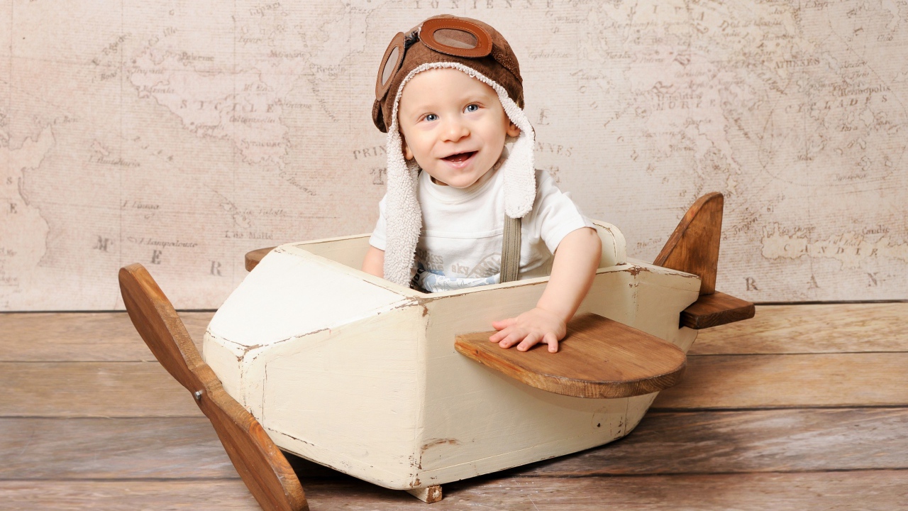 Улыбающийся маленький мальчик в игрушечном самолете