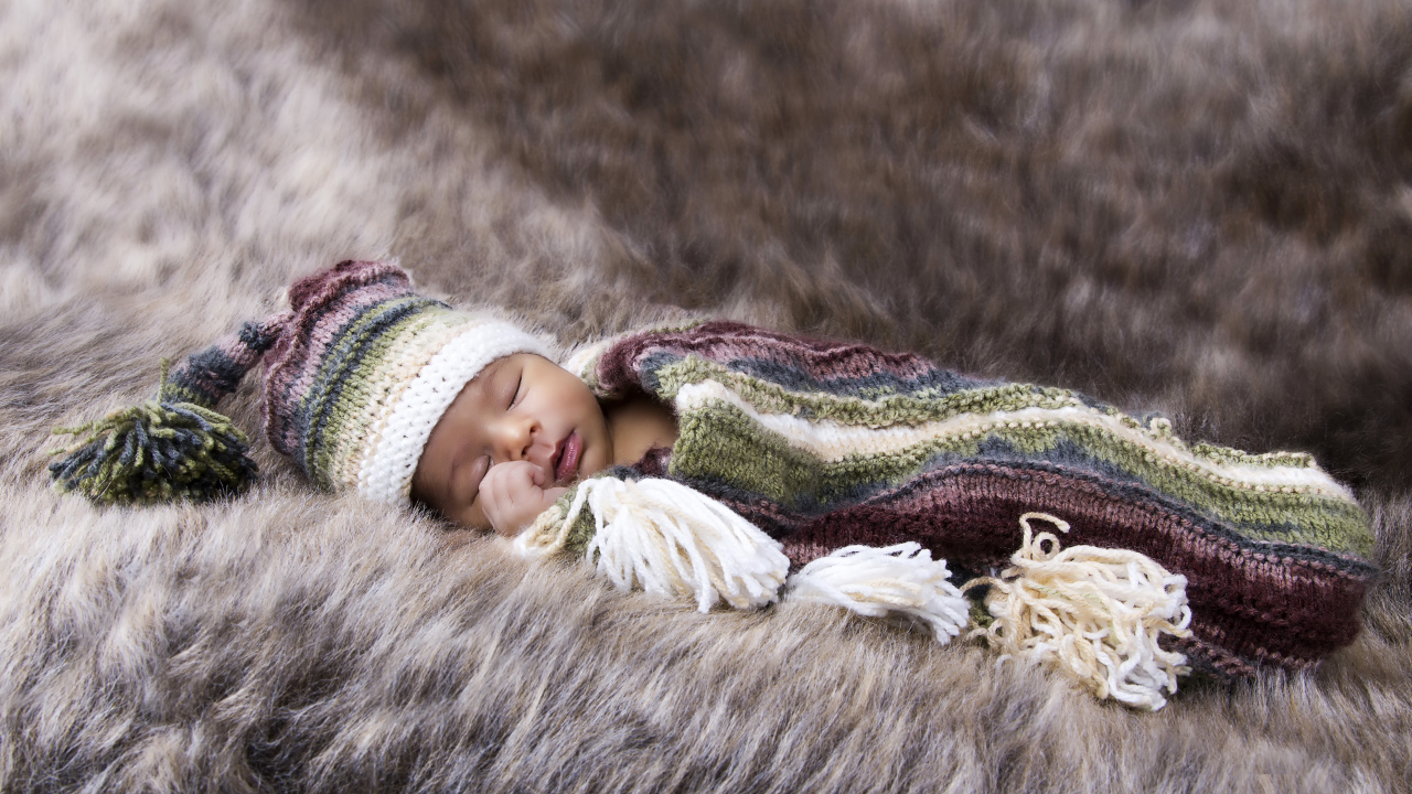 Младенец спит на меховом покрывале