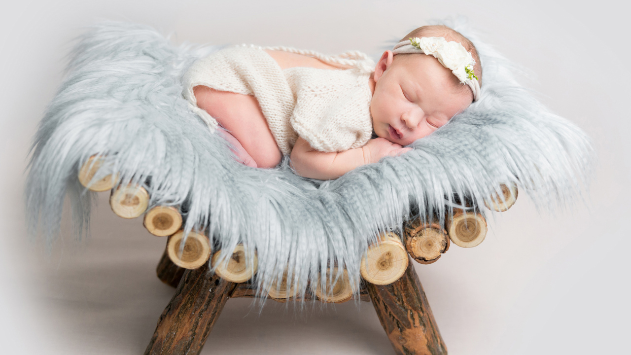 Грудной спящий ребенок лежит на деревянной кроватке