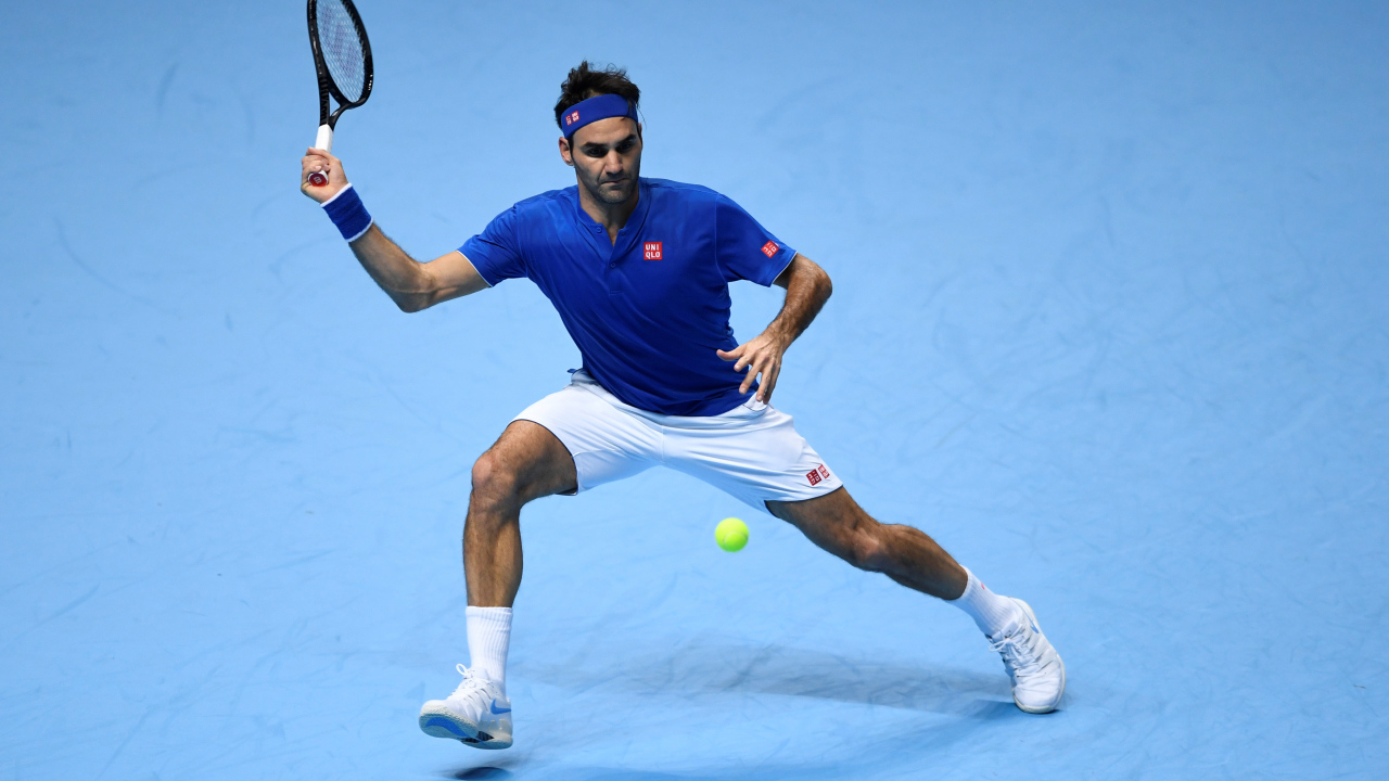 Теннисист Роджер Федерер отбивает мяч ракеткой на корте 