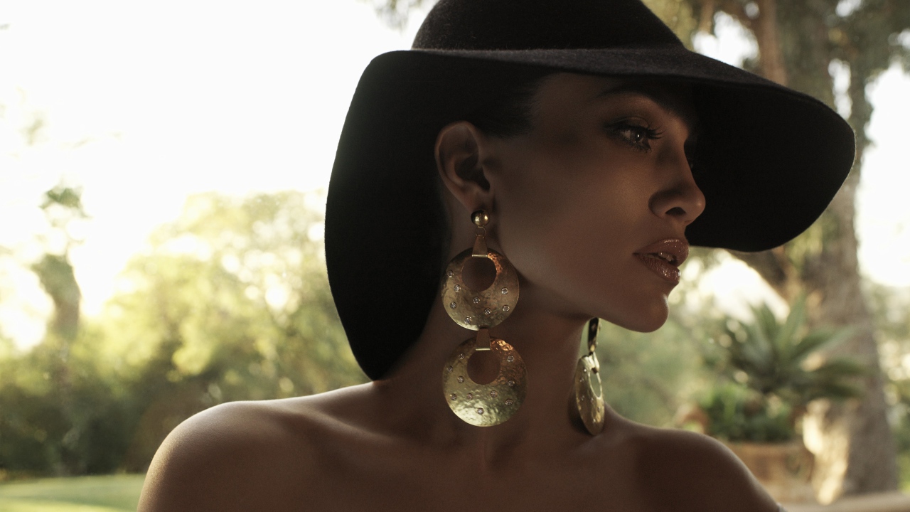 Актриса Дженнифер Лопес в большой черной шляпе