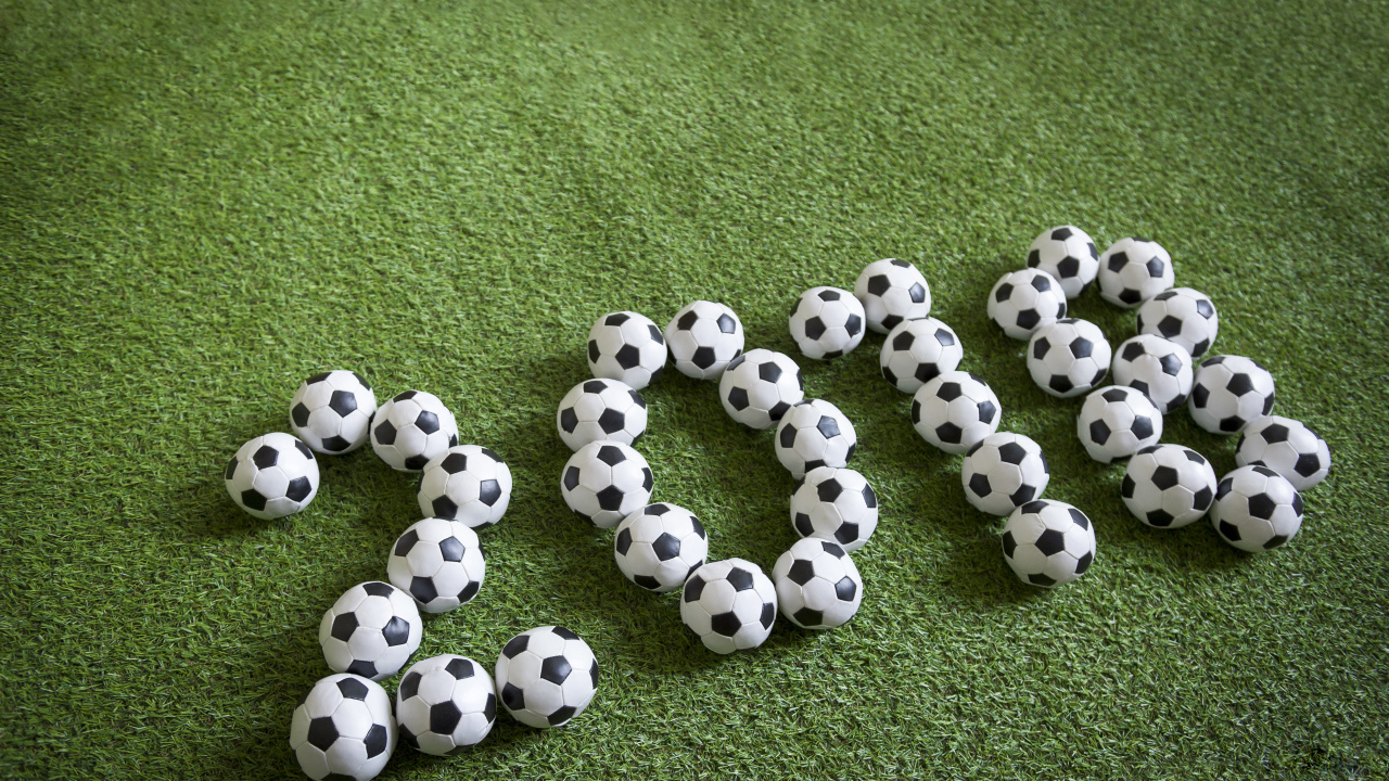 Цифры 2018 из футбольных мячей на зеленой траве